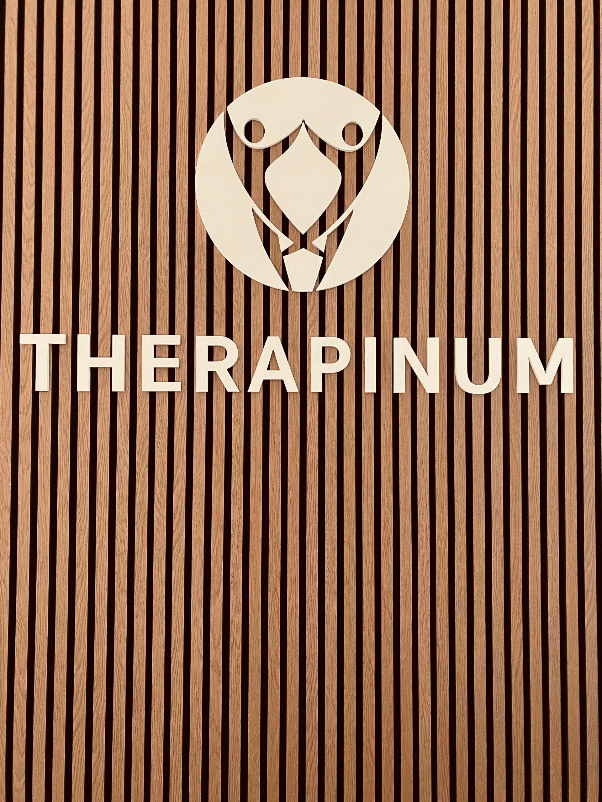 eine Tafel mit dem Logo und Namen von therapinum im Büroflur von therapinum
