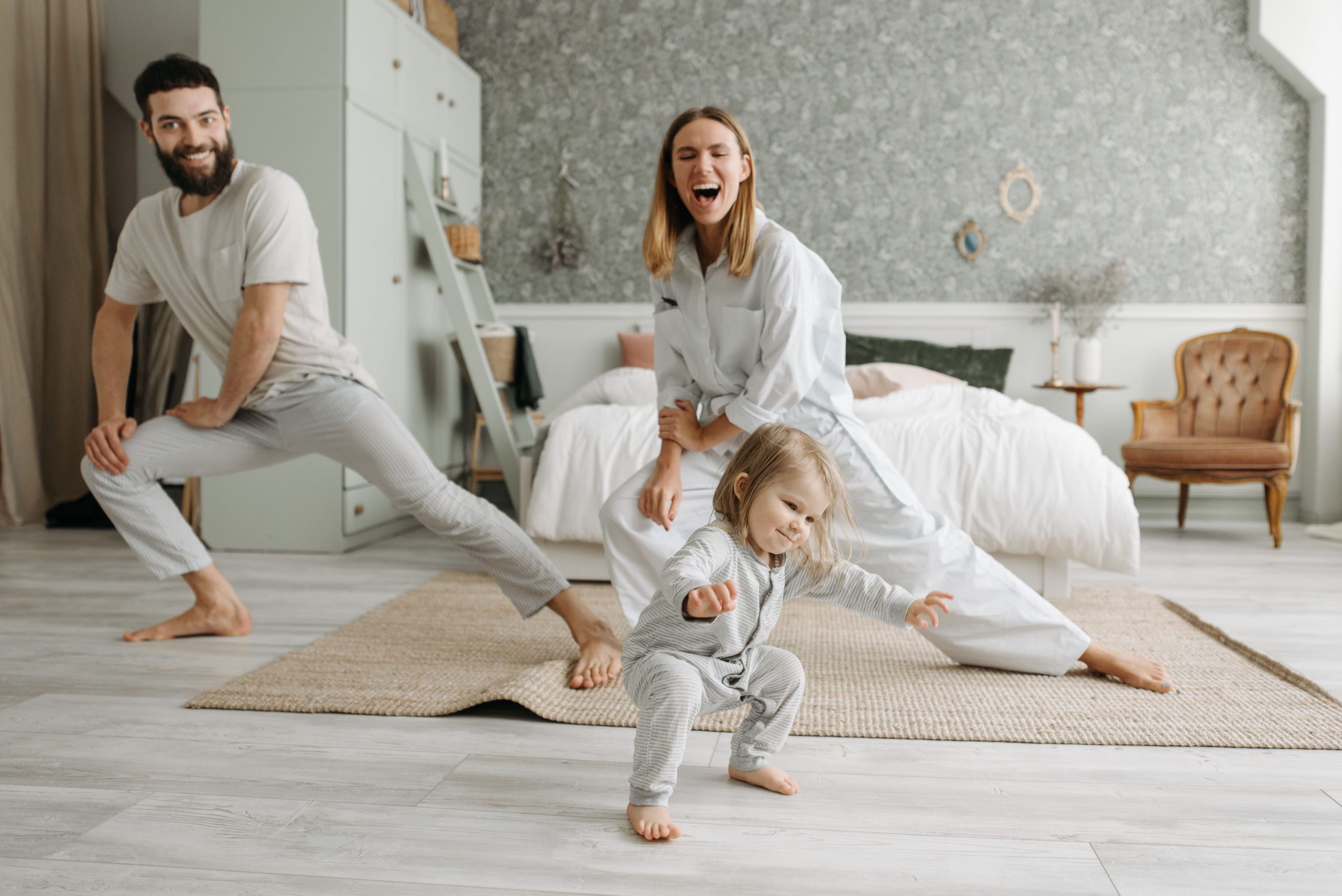 ein Bild, das eine glückliche Familie zeigt, bestehend aus Vater, Kind und Mutter, die gemeinsam Dehnübungen machen - dieses Gefühl möchte therapinum vermitteln