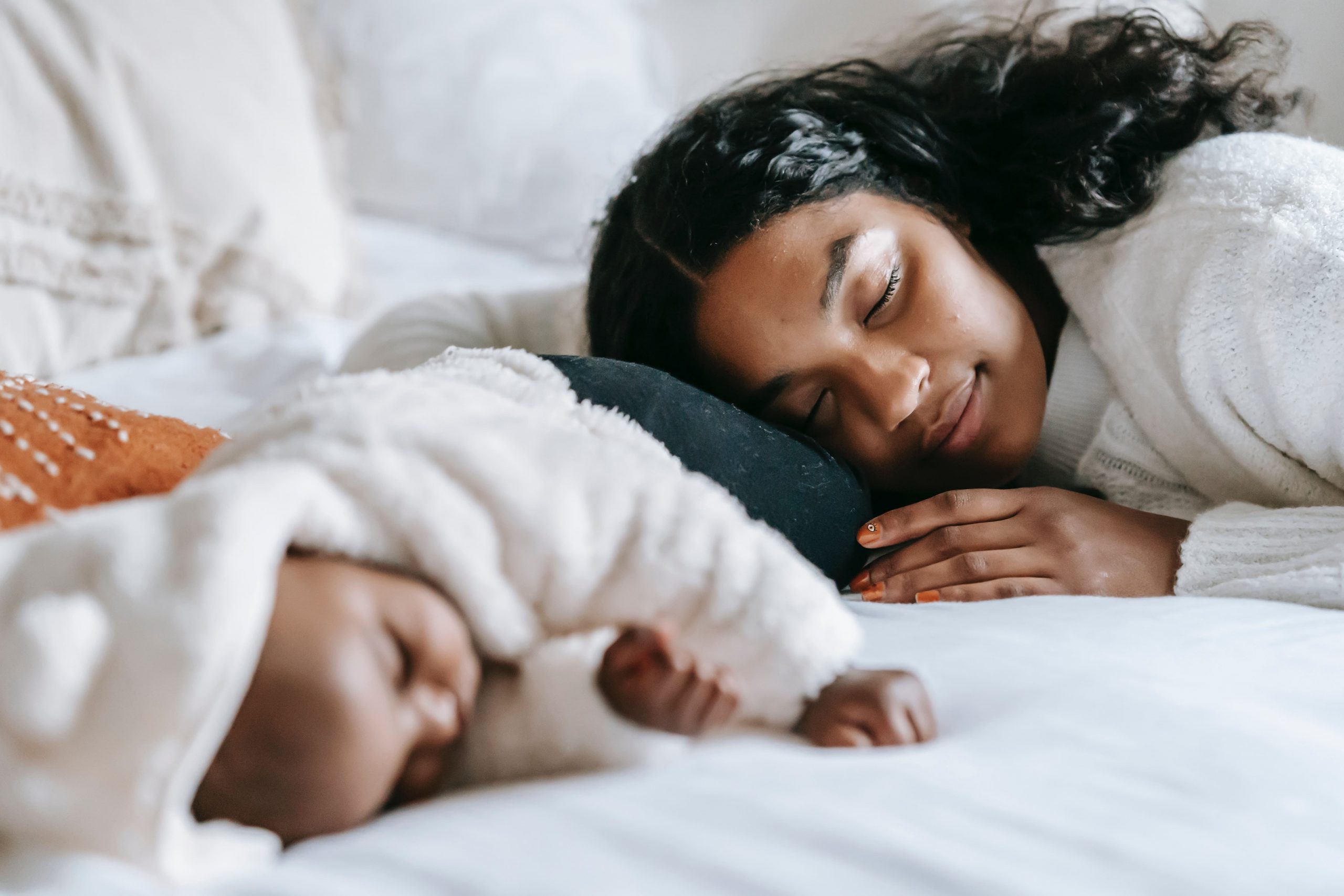 ein Bild, das eine glückliche Mutter und ein fest schlafendes Baby zeigt, ist ein Gefühl, das therapinum vermitteln möchte